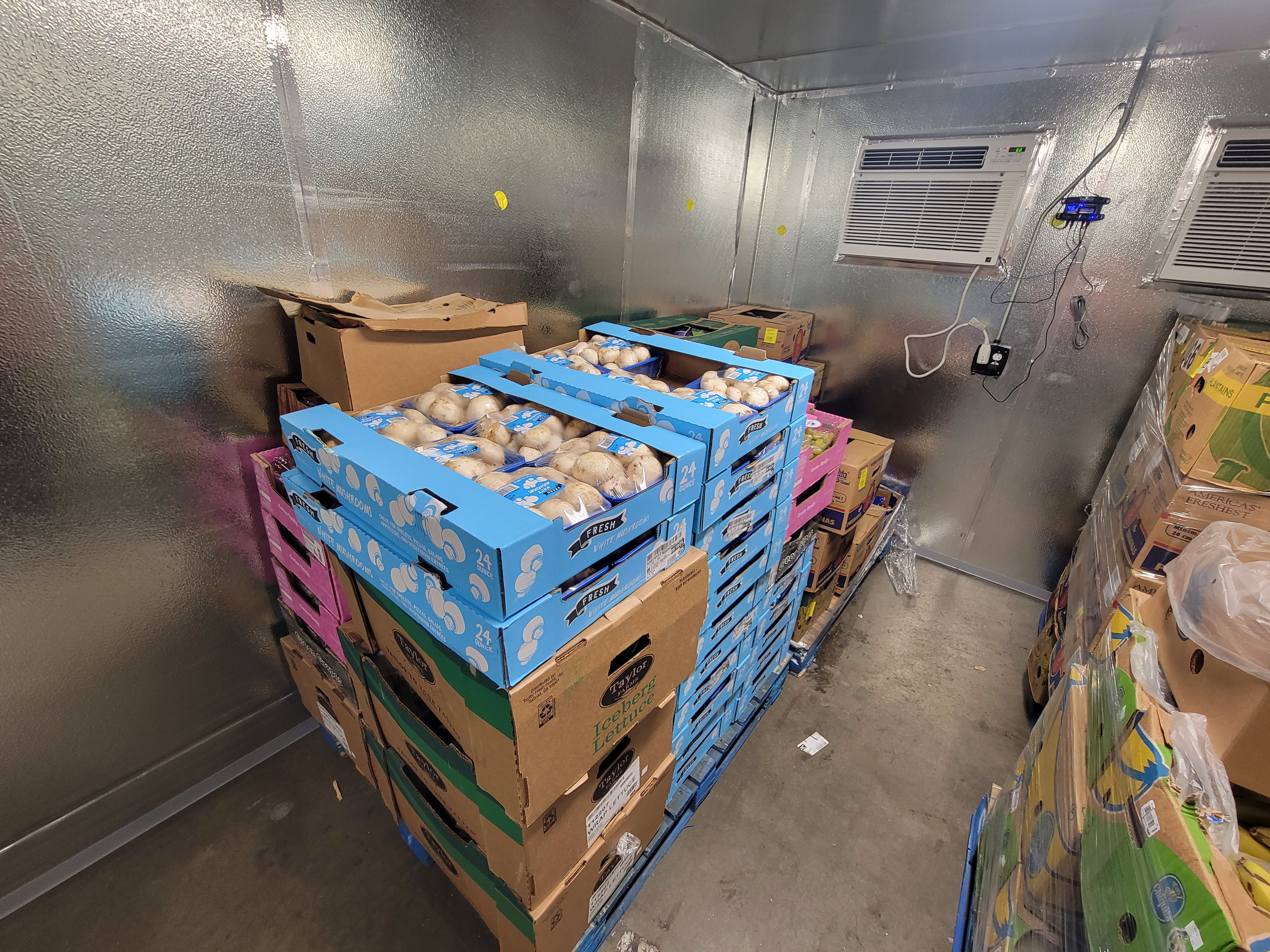 Produce filled boxes in a fridge box unit.